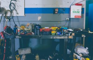 Workbench for garage and workshop covered in equipment in a dark and dirty room